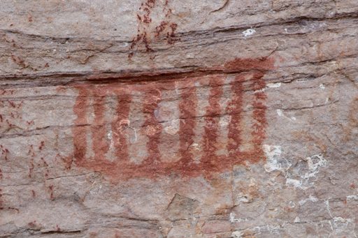 Recorded panel: red anthropomorphs on pale rock